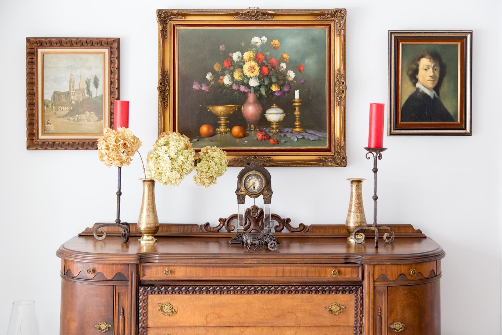 Brass candlesticks, hydrangeas and a mantel clock on the dining room sideboard