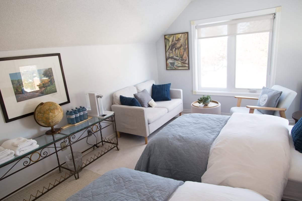 The Blue Room looking toward the sofa and window, with towels and water set out on the console