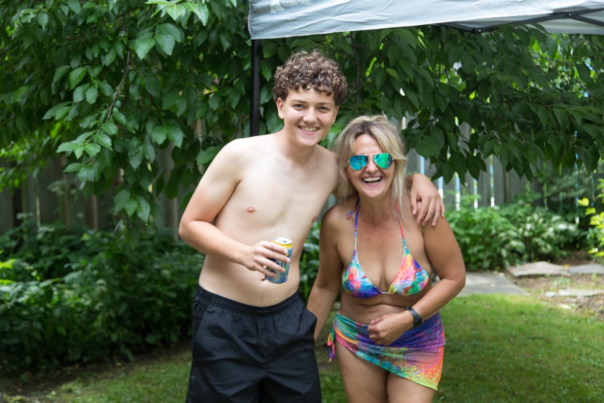 Two guests smiling together at a backyard summer gathering