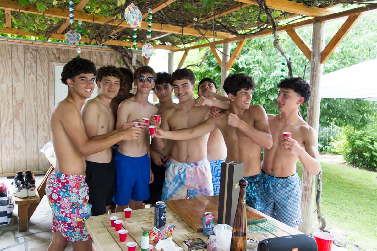 A group celebrating a birthday together under the vine-covered pergola in the backyard