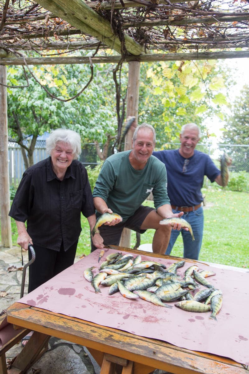 Grandmother and family admiring the perch catch laid out under the pergola